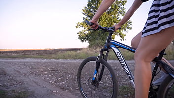 Hot girl teases ass under skirt while rides a bike outdoor
