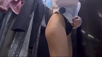 A woman undresses in a public dressing room