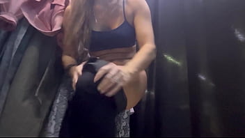 A woman undresses in a public dressing room