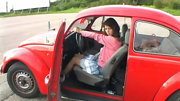 Bimba siting barefoot in her volkswagen car revving the engine