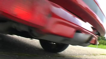 Bimba siting barefoot in her volkswagen car revving the engine