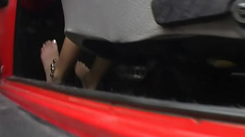 Bimba siting barefoot in her volkswagen car revving the engine