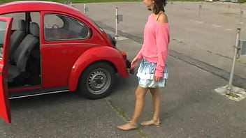 Bimba siting barefoot in her volkswagen car revving the engine