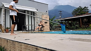 Latina caliente se toca viendo al piscinero hacer su trabajo