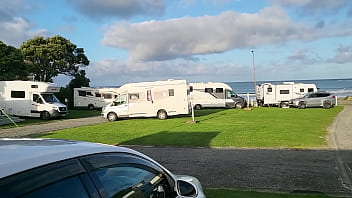 Trashy milf slut pees on the grass in front of other campers at the beach