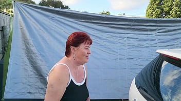 Trashy milf slut pees on the grass in front of other campers at the beach