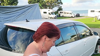 Trashy milf slut pees on the grass in front of other campers at the beach