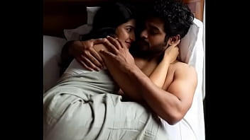 Erotic kissing scene of woman and man on bed in saree
