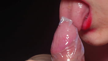 Blowjob in a condom very close up red lips caress and lick the penis Blowjob in a condom very close up red lips caress and lick the penis
