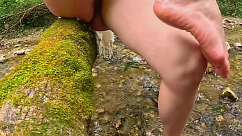 Naked girl walks in the stream and masturbates passionately