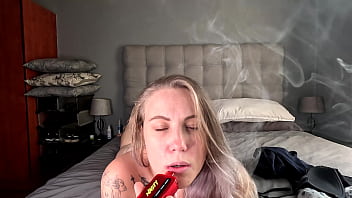 Tattooed blonde taking off her clothes smokes her vape naked