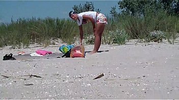 A couple of nudism lovers hardly pairing off on the sand