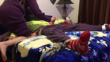 Tied spread eagle to a bed while sweater mistress uses him