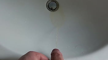 Boy is pissing in the sink and makes stinky farts