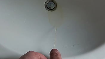 Boy is pissing in the sink and makes stinky farts