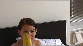 How young brunette girl teaches using a banana