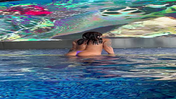 Monika fox in purple bikini swims in pool & poses by window against background of city free