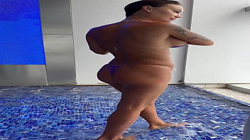 Monika fox in purple bikini swims in pool & poses by window against background of city free