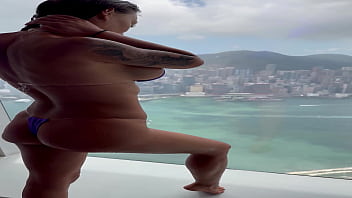 Monika fox in purple bikini swims in pool & poses by window against background of city free