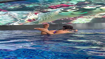 Monika fox in purple bikini swims in pool & poses by window against background of city free