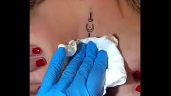 Loira com os peitos enorme mostrando sua tatuagem sem timidez