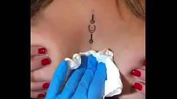 Loira com os peitos enorme mostrando sua tatuagem sem timidez