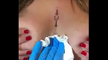Loira com os peitos enorme mostrando sua tatuagem sem timidez