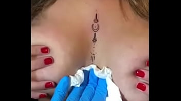 Loira com os peitos enorme mostrando sua tatuagem sem timidez