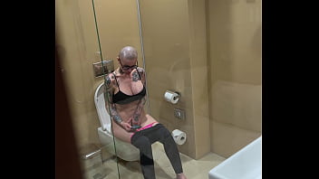 Busty girl watches porn and jerks off on the toilet peeping