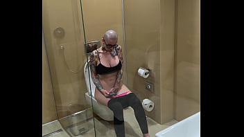 Busty girl watches porn and jerks off on the toilet peeping