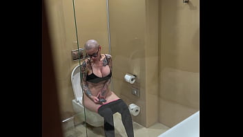 Busty girl watches porn and jerks off on the toilet peeping