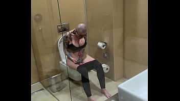 Busty girl watches porn and jerks off on the toilet peeping