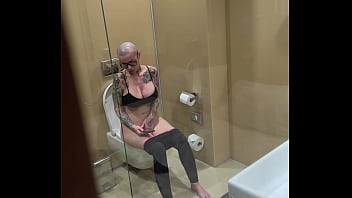 Busty girl watches porn and jerks off on the toilet peeping