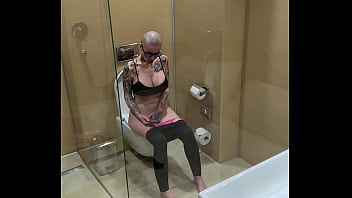 Busty girl watches porn and jerks off on the toilet peeping