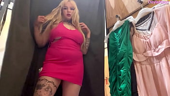Beautiful stepmother changing clothes in a clothing store shooting in the dressing room