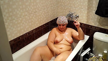 A mature bbw lay down in the bath lit a cigarette and smokes relish