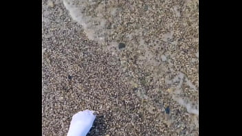 Playing with my feet in white socks with pebbles on the beach