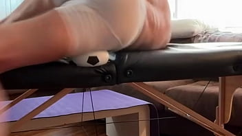 Groin stretch in tight spandex shorts with mini football soccer ball on stool and table slowed down time lapse