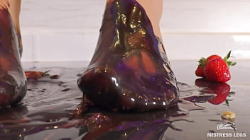 Goddess messy her nylon feet in chocolate close up and squeezing strawberries